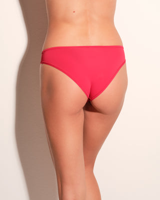 Woman wearing red bikini underwear against a plain background