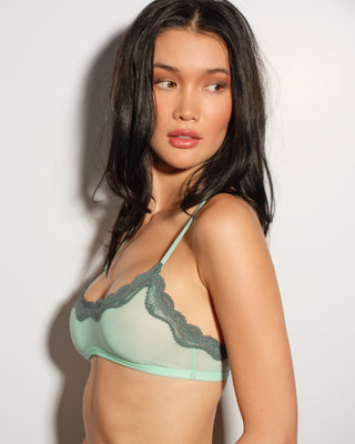 A woman wearing an aqua blue bralette with lace trim