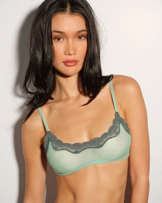 A woman wearing an aqua blue bralette with lace trim