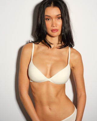 A woman wearing a white pushup bra and panties