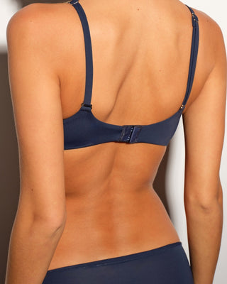 Navy blue bra worn by a person on a plain background