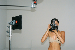 Person taking a photo with a camera in a studio setting